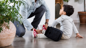 Mom helping boy put on shoes